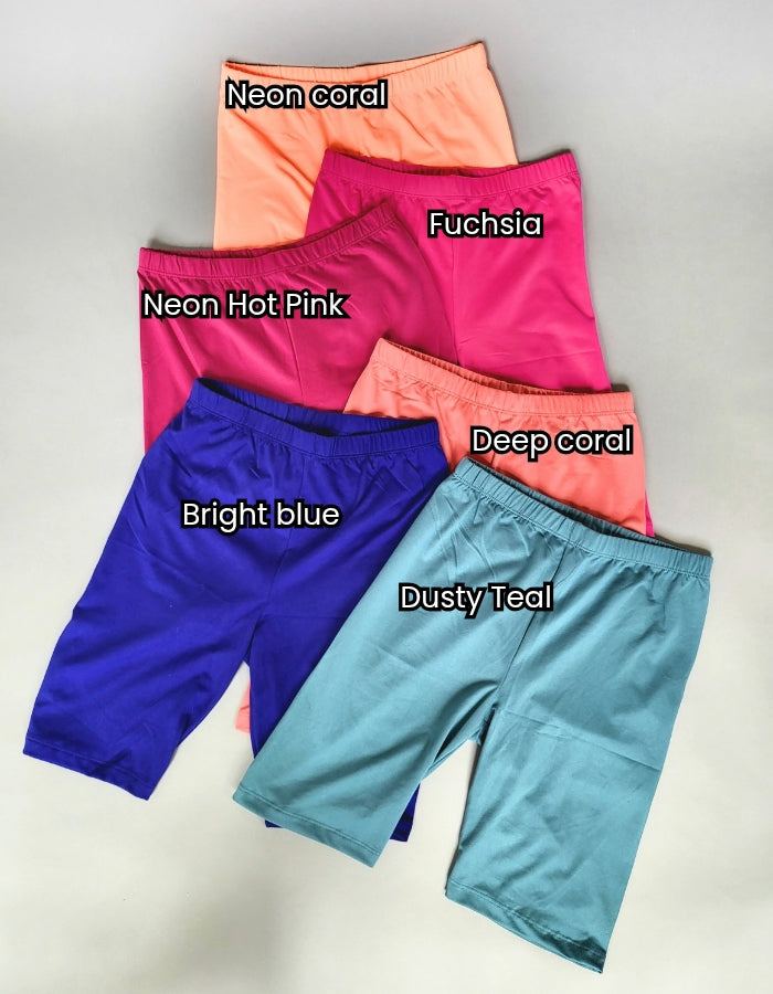 Microfiber Biker Shorts In The Colors Neon Coral, Fuchsia, Neon Hot Pink, Deep Coral, Bright Blue, and Dusty Teal